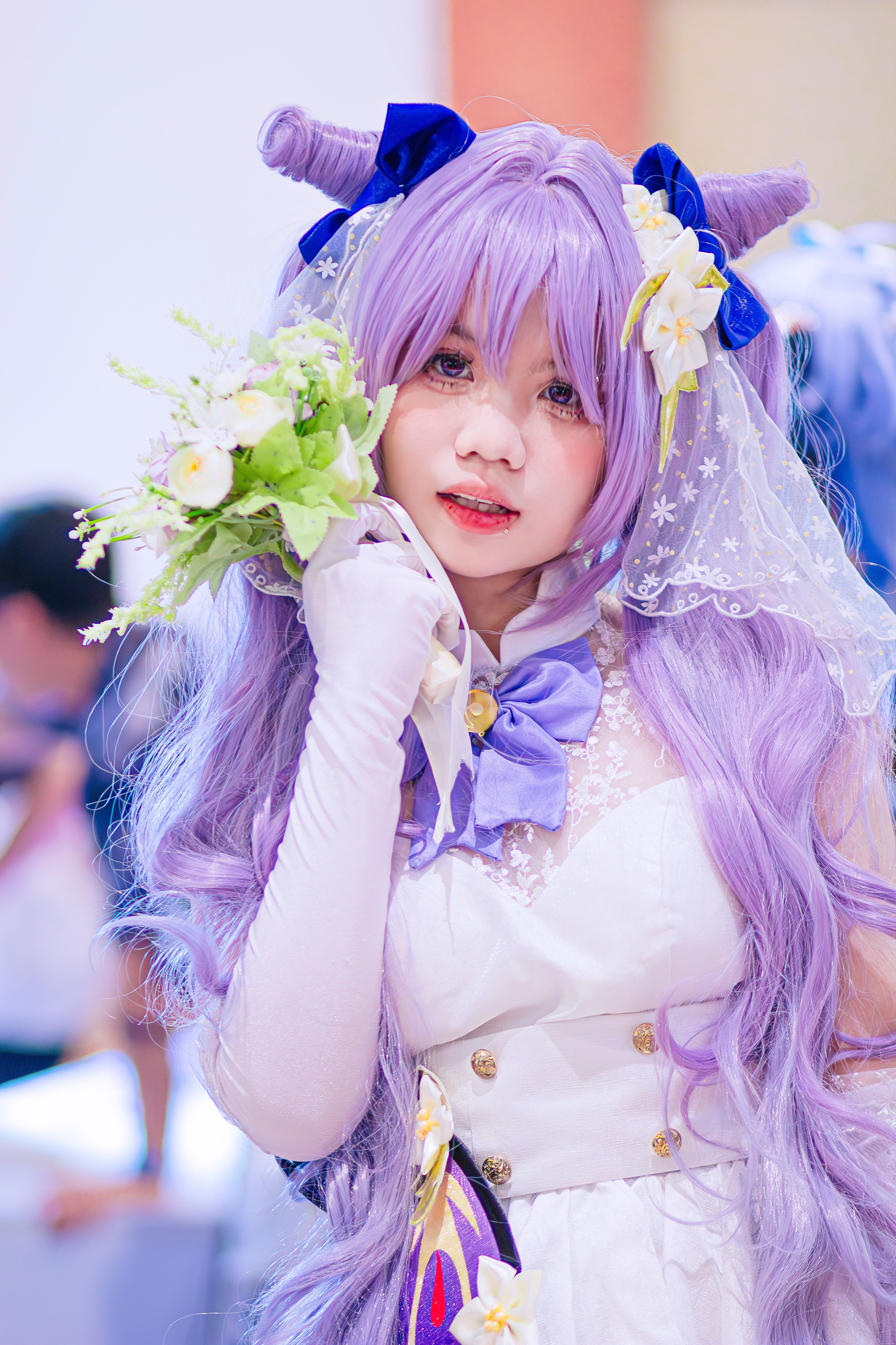 Anime-inspired cosplay with purple wig and vibrant costume in an indoor setting.