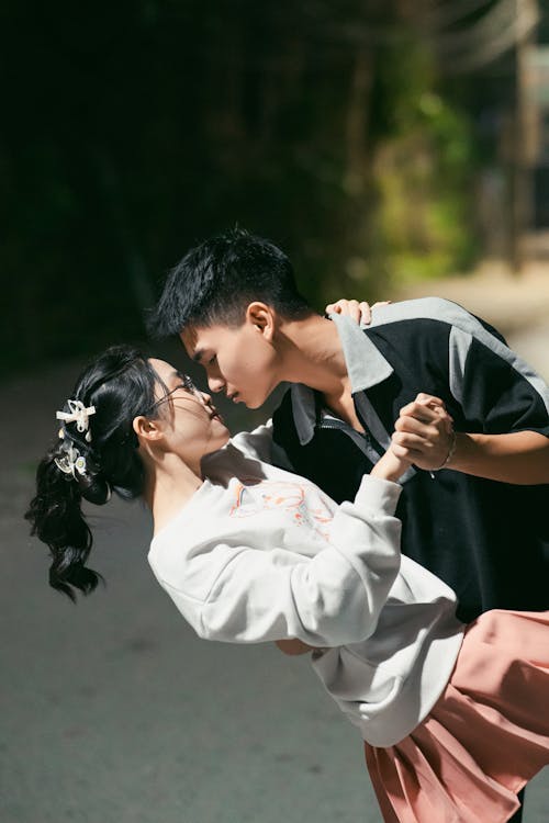 A young couple is dancing together on the street