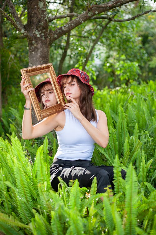 Young Woman Among Ferns Posing with a Mirror