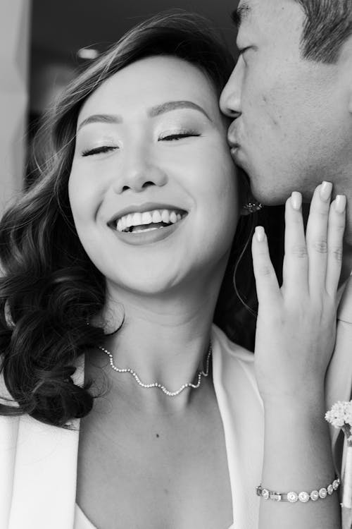 Black and White Photograph of a Man Kissing a Woman