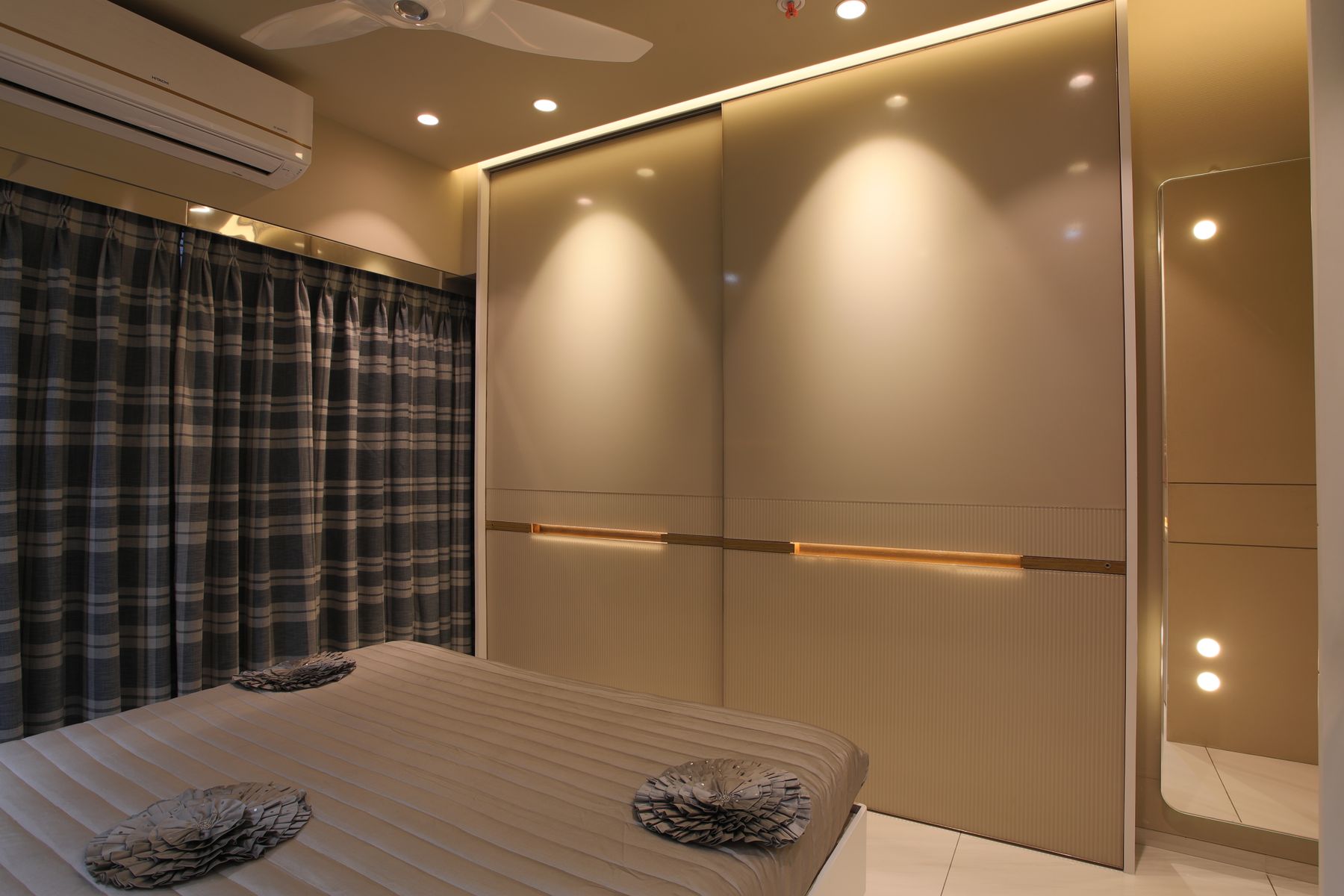Calm bedroom with curved furniture, warm ambient light, restrained bedding and clear floor