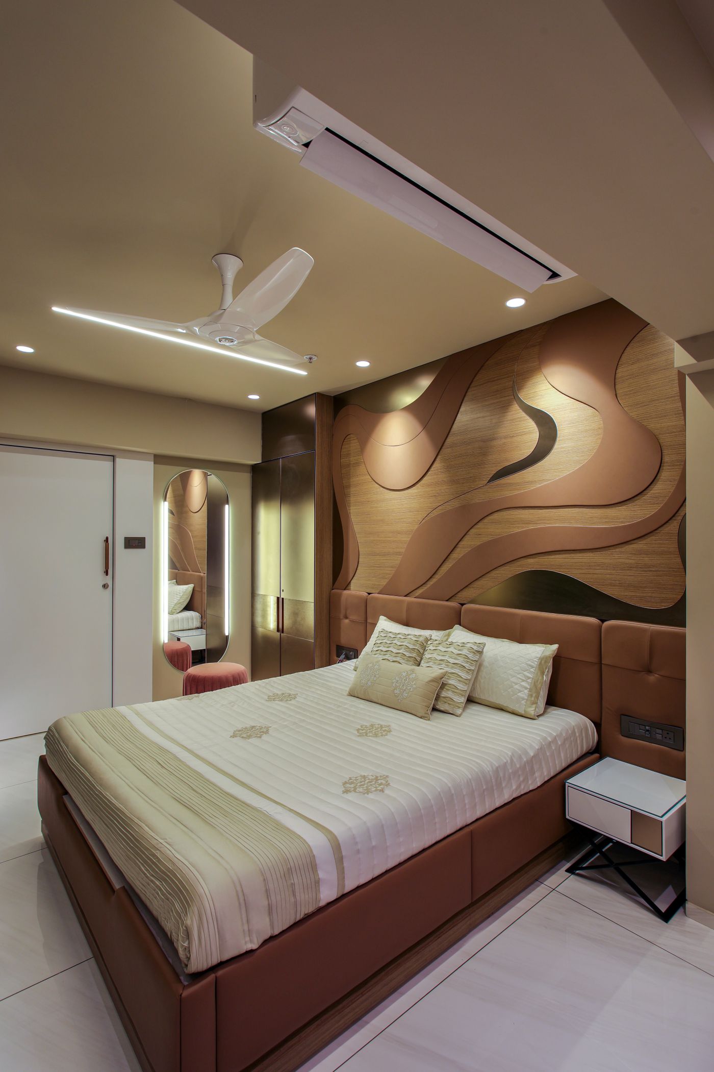 Bedroom with a sculpted timber headboard wall and soft concealed light