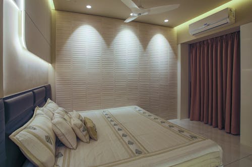 A bedroom with a bed, a ceiling fan and a light fixture