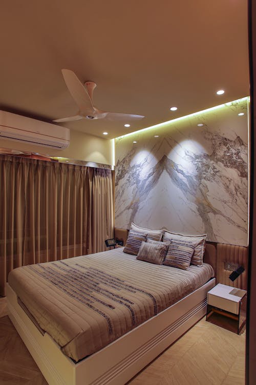 A bedroom with a large bed and a ceiling fan