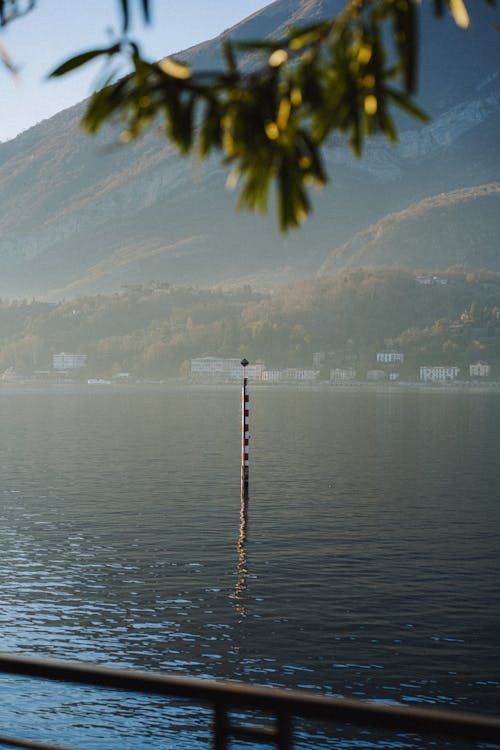 A pole with a flag on it in front of a lake
