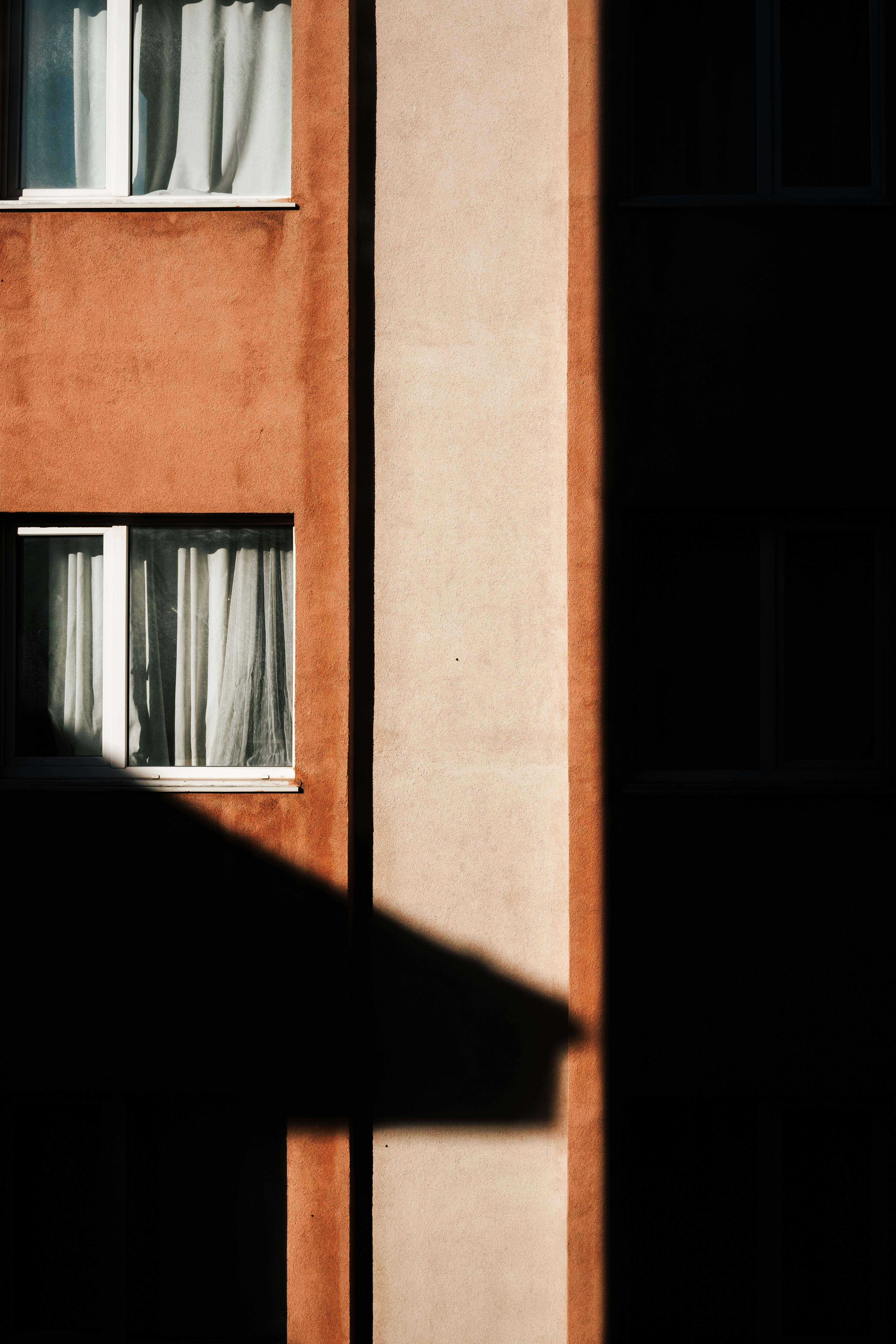 A geometric shadow cast on the facade of a residential building in İstanbul, capturing urban architecture.