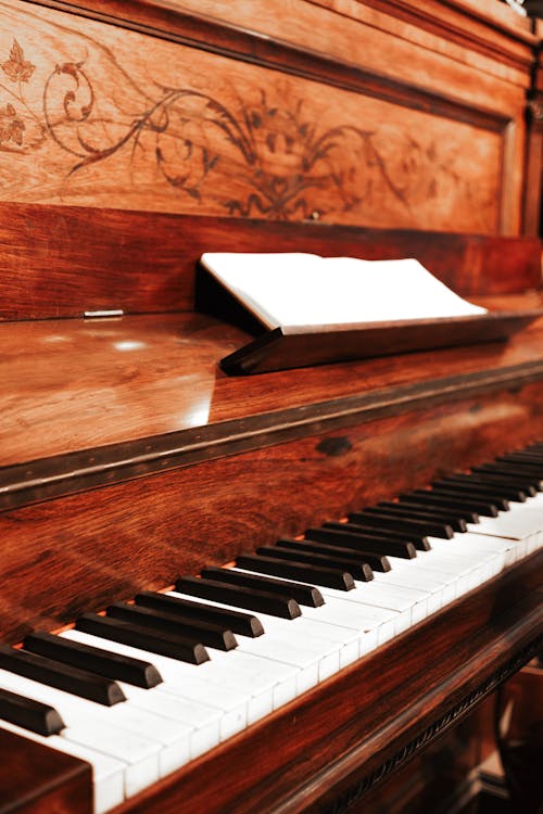 A piano with a wooden case and a book on it