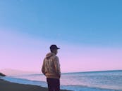 Man In Hoodie Standing On Seashore
