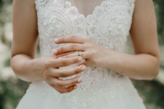 Elegant close-up of a bride's hands showcasing a beautiful engagement ring on her wedding day.