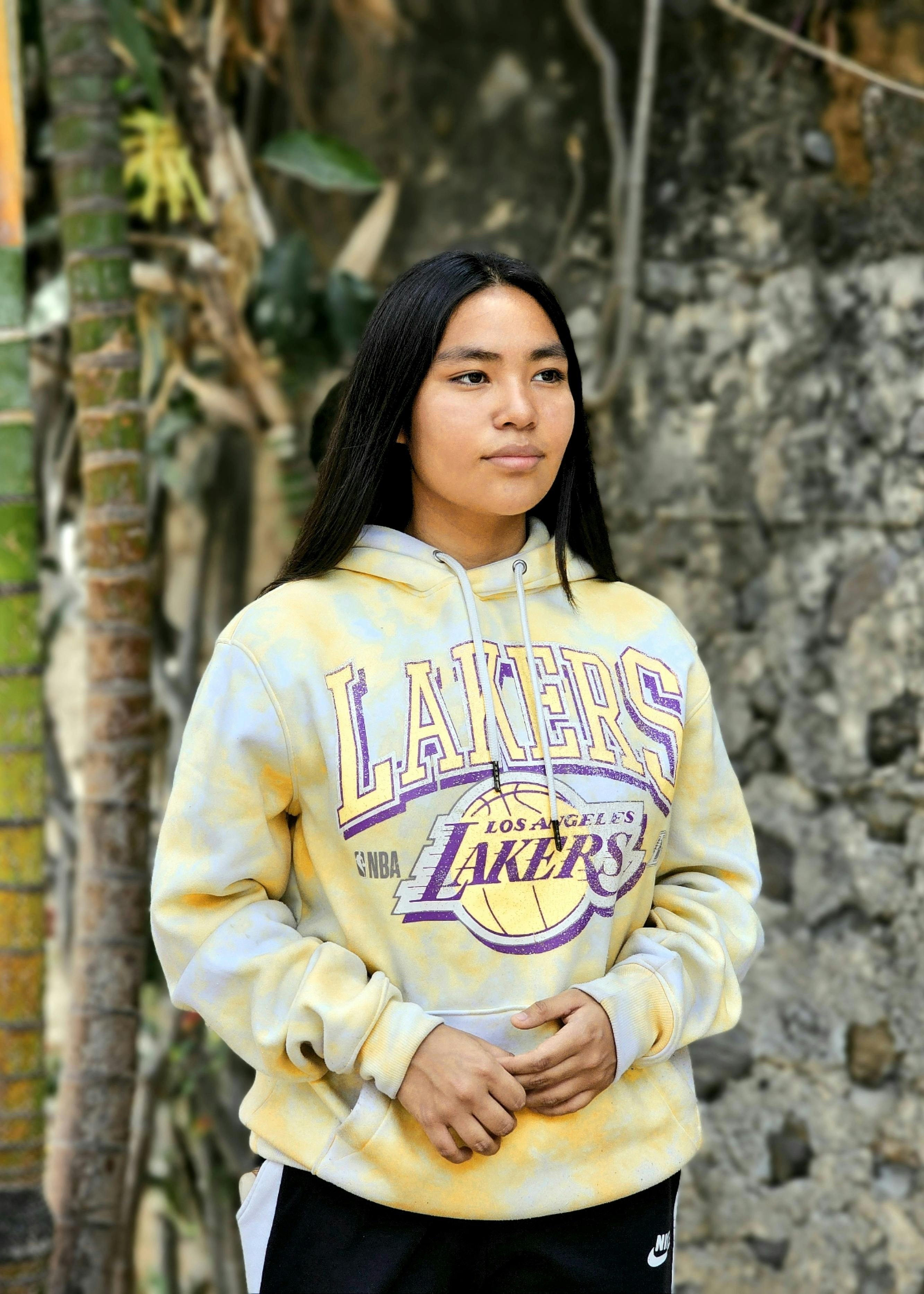 woman in sports team hoodie standing under bamboo