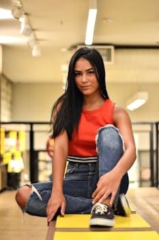 一位穿着休闲装的年轻女子坐在室内，肖像散发着自信和时尚