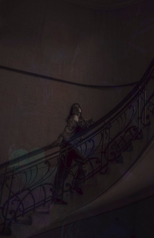 A woman is standing on the stairs of a building