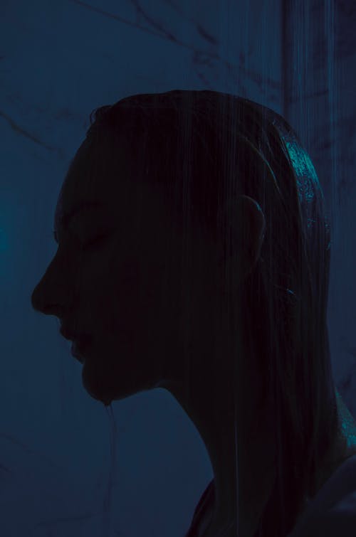 A woman with her head in the shower