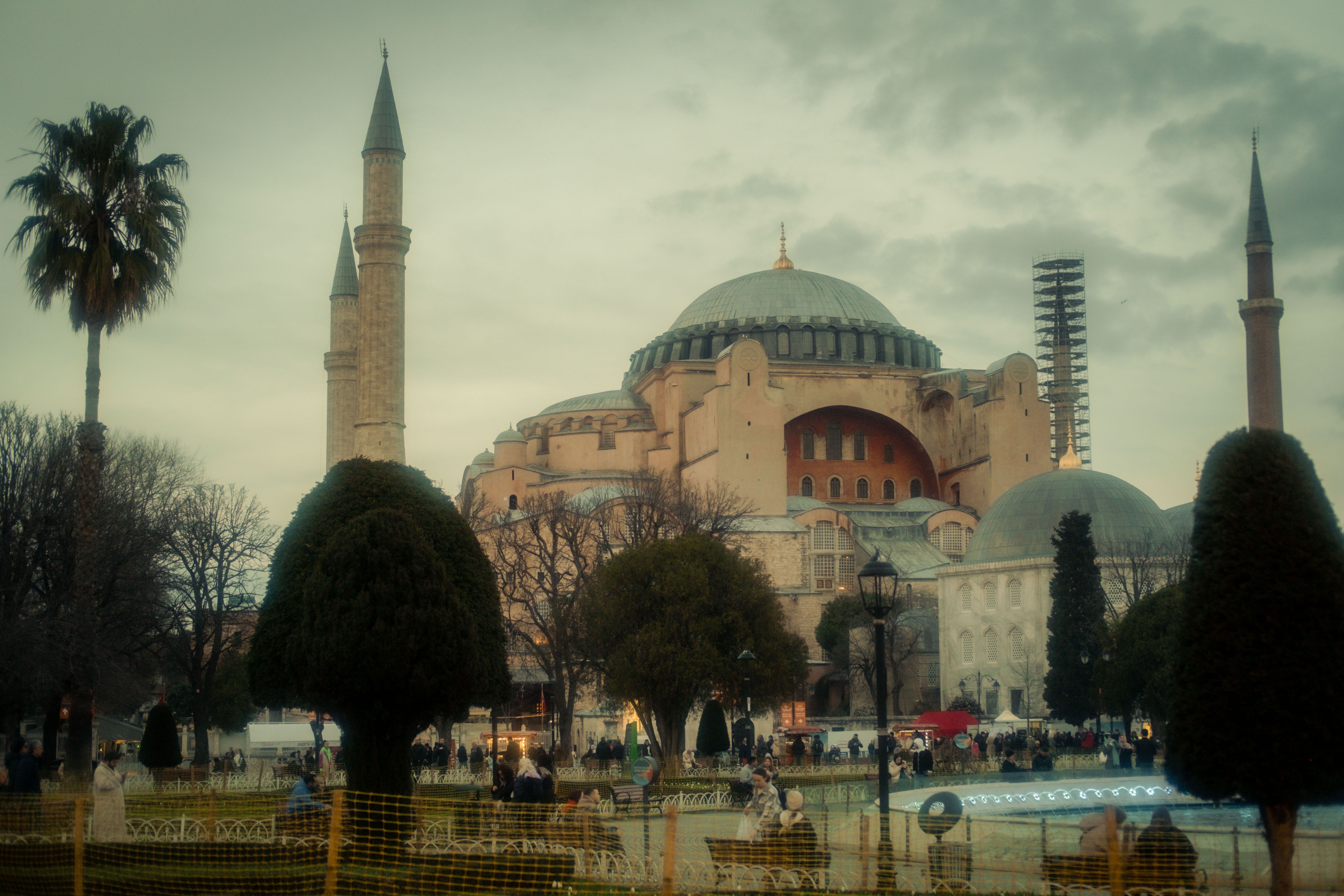 Hagia Sophia with its iconic domes and minarets under a cloudy sky in Istanbul, Turkey.