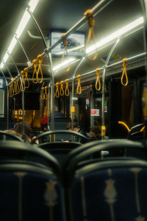 Free Passengers riding a bus at night with soft lighting and a cozy atmosphere. Stock Photo