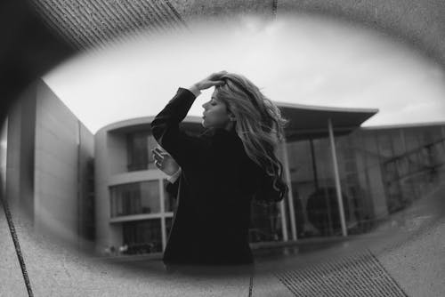 Reflection of Blonde Woman Fixing her Hair