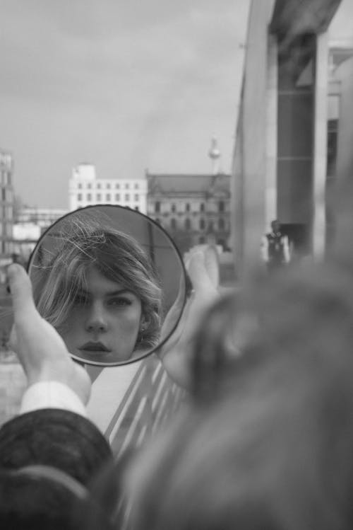A woman is looking at herself in a mirror