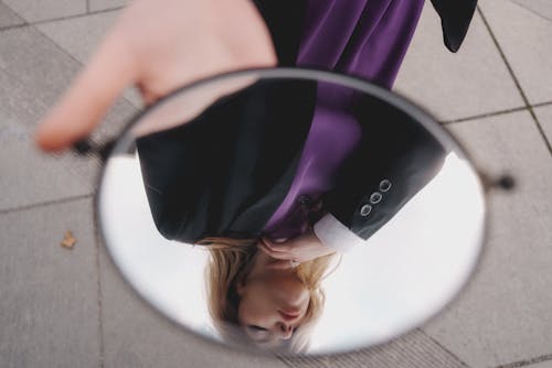 A woman is holding a mirror in her hand