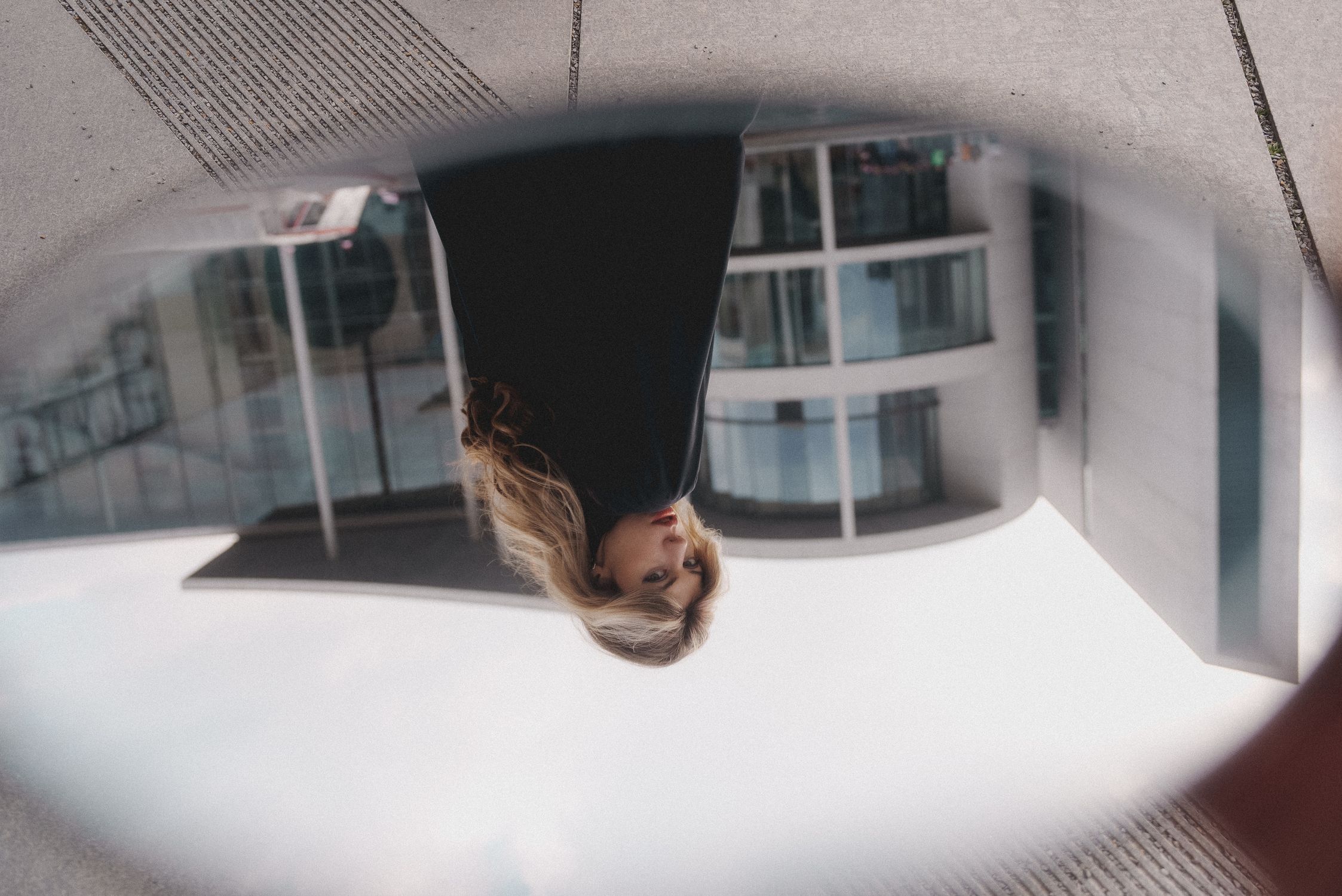 Inverted Mirror. View Inverted Reflection of a Beautiful Blonde Woman in a Small Mirror ...