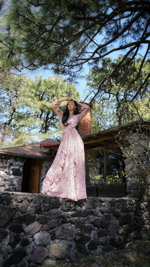 A woman in a pink dress standing on a rock
