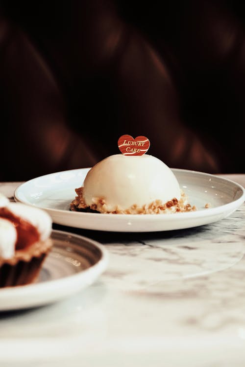 Two desserts on a plate with a heart on top