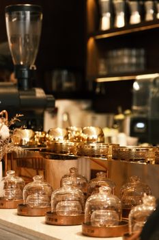 Warm and inviting café interior highlighting glass containers on a wooden counter.