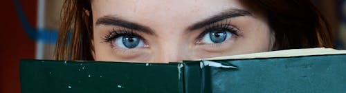 無料 グリーンブックで顔を覆う女性 写真素材