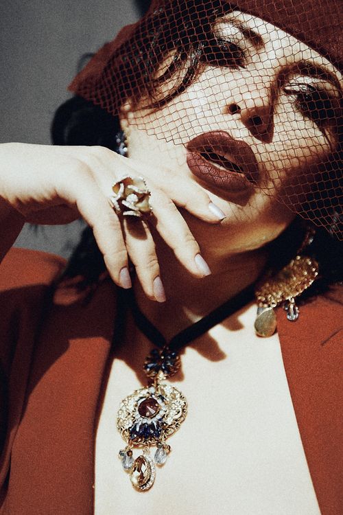 Free Artistic fashion portrait of a woman wearing jewelry and a red outfit, showcasing elegance. Stock Photo