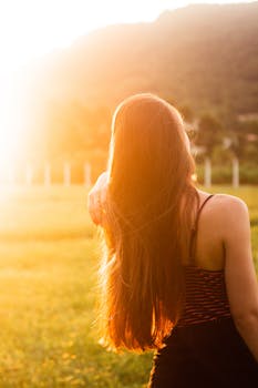 一名年轻女子留着长发，在巴西南里约热内卢附近的田野里欣赏日落