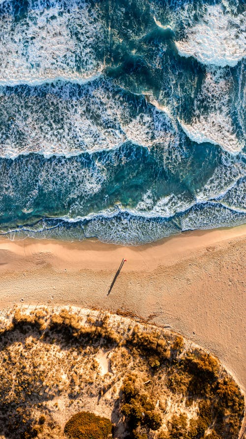 Aerial Footage of a Blue Rough Sea and a Sandy Beach