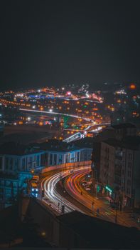 Long exposure of bustling night traffic and cityscape in Trabzon, Türkiye capturing vibrant lights.