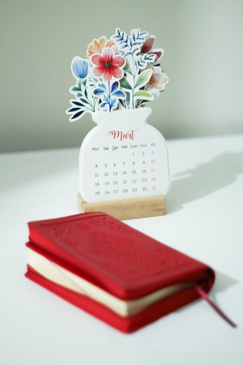 Notebook Next to a Calendar