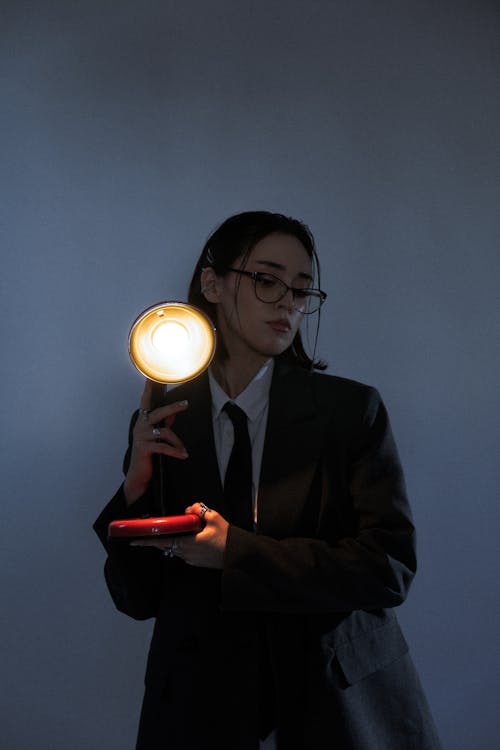 A woman in a suit holding a flashlight