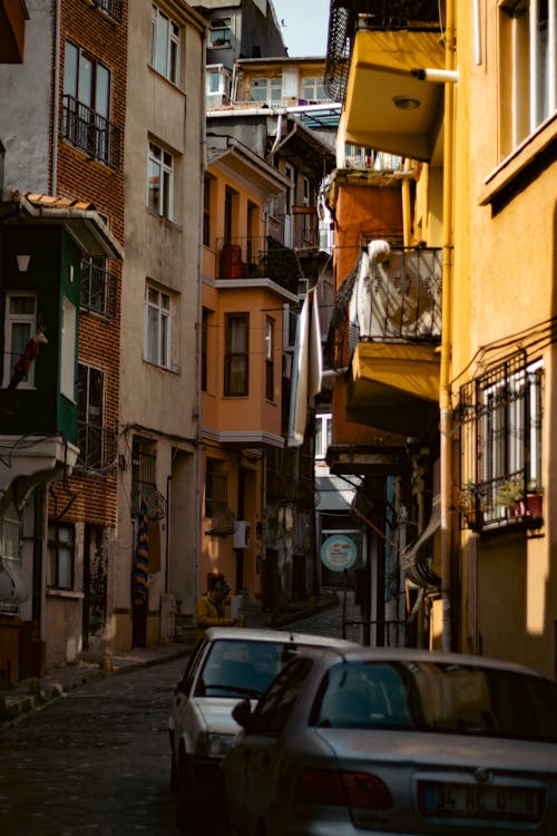 A narrow street with cars parked in front of it