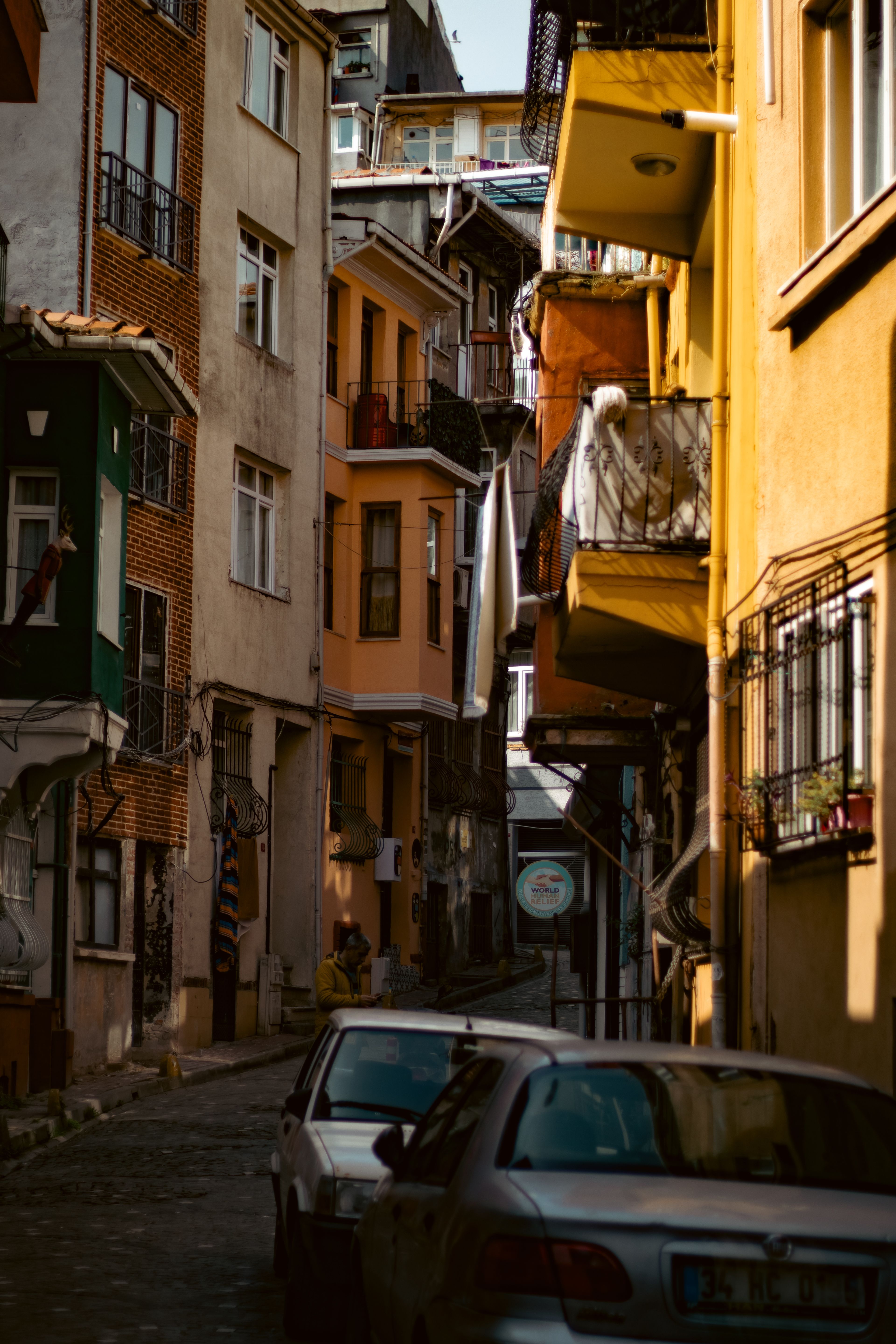 A narrow street with cars parked in front of it · Free Stock Photo