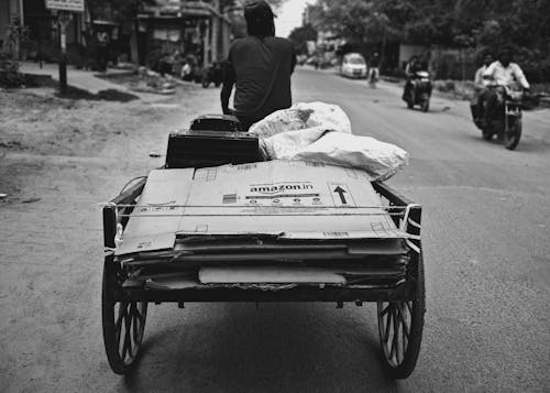 A man pushing a cart down a street