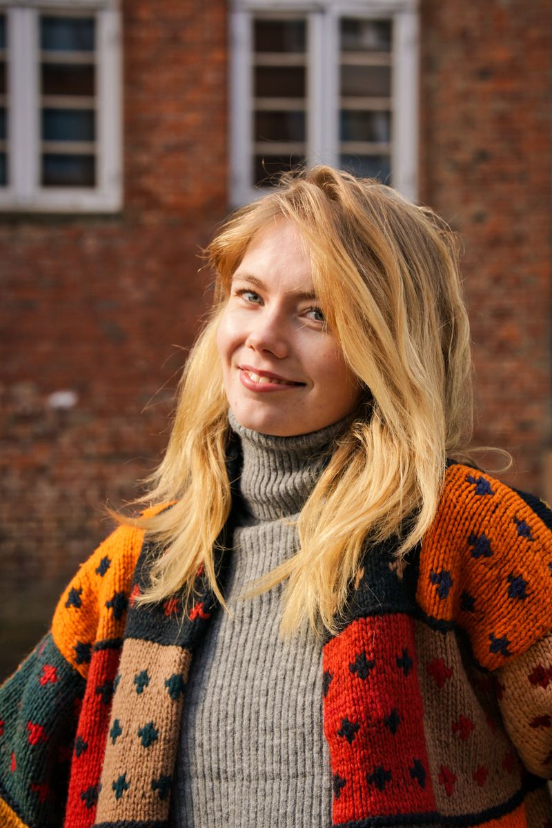 Smiling woman with long blonde hair and a colourful cardigan