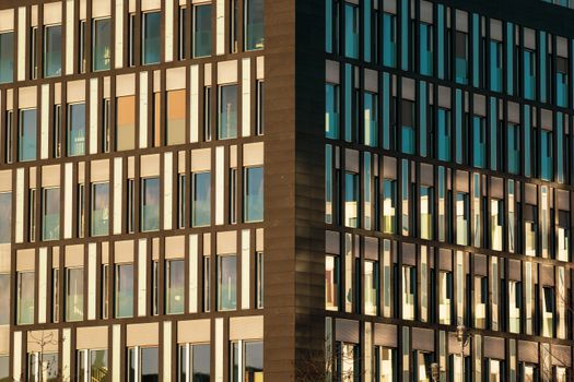Contemporary urban office building featuring reflective glass windows and modern design.