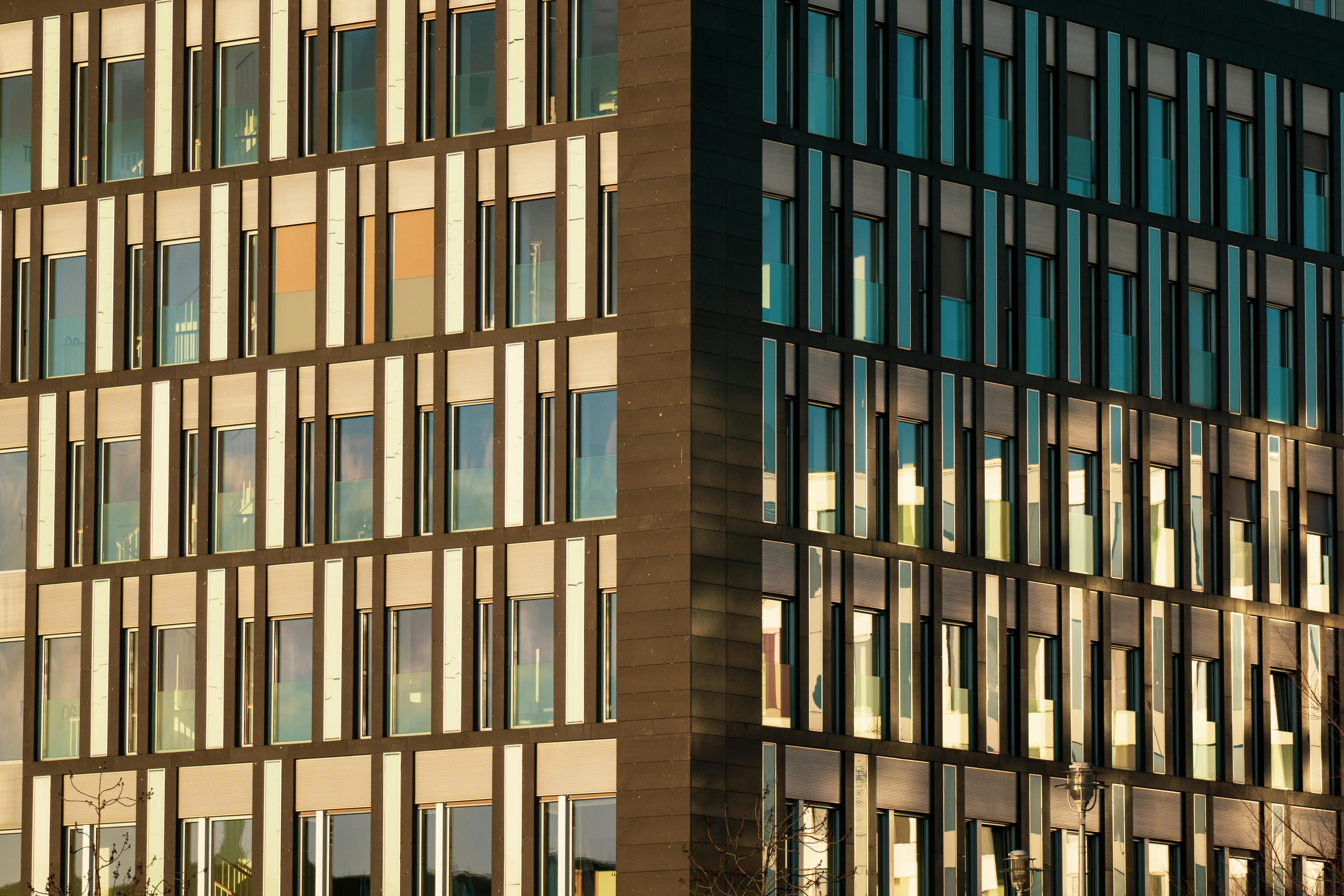 Free Contemporary urban office building featuring reflective glass windows and modern design. Stock Photo