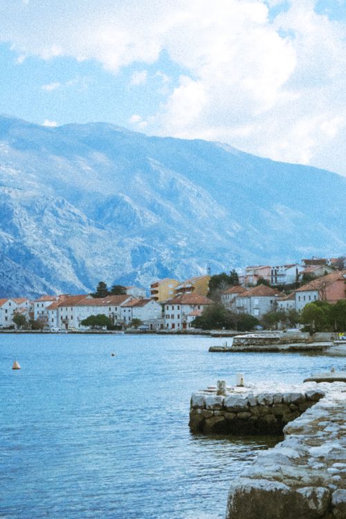 Free Beautiful view of a coastal town set against majestic mountains and serene sea in Montenegro. Stock Photo