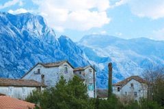 Charming village houses set against a stunning mountain landscape under a bright sky.