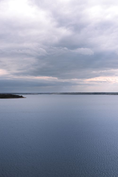 Free A tranquil ocean horizon with a cloudy sky, evoking calmness and peace. Stock Photo