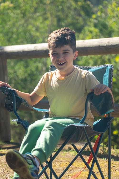 A young boy sitting in a camping chair