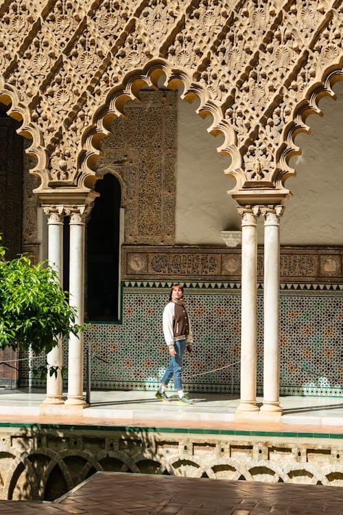 A man walking through an arched doorway in a courtyard