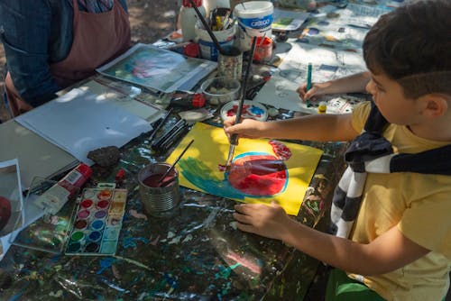 A child painting with a brush on a table