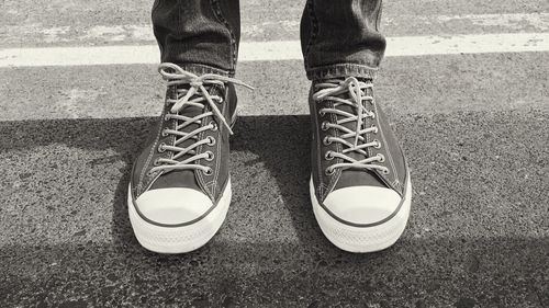 Free Close-up of casual sneakers on asphalt in black and white. Stock Photo