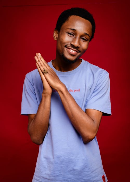 A young man in a blue shirt is posing for a photo