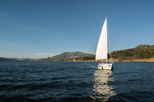 A sailboat on the water with mountains in the background