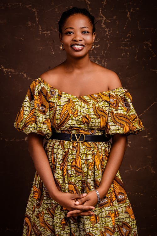 A woman in an african print dress posing for a photo