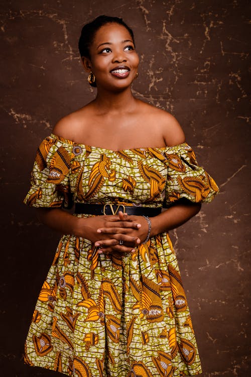 A woman in an african print dress posing for a photo